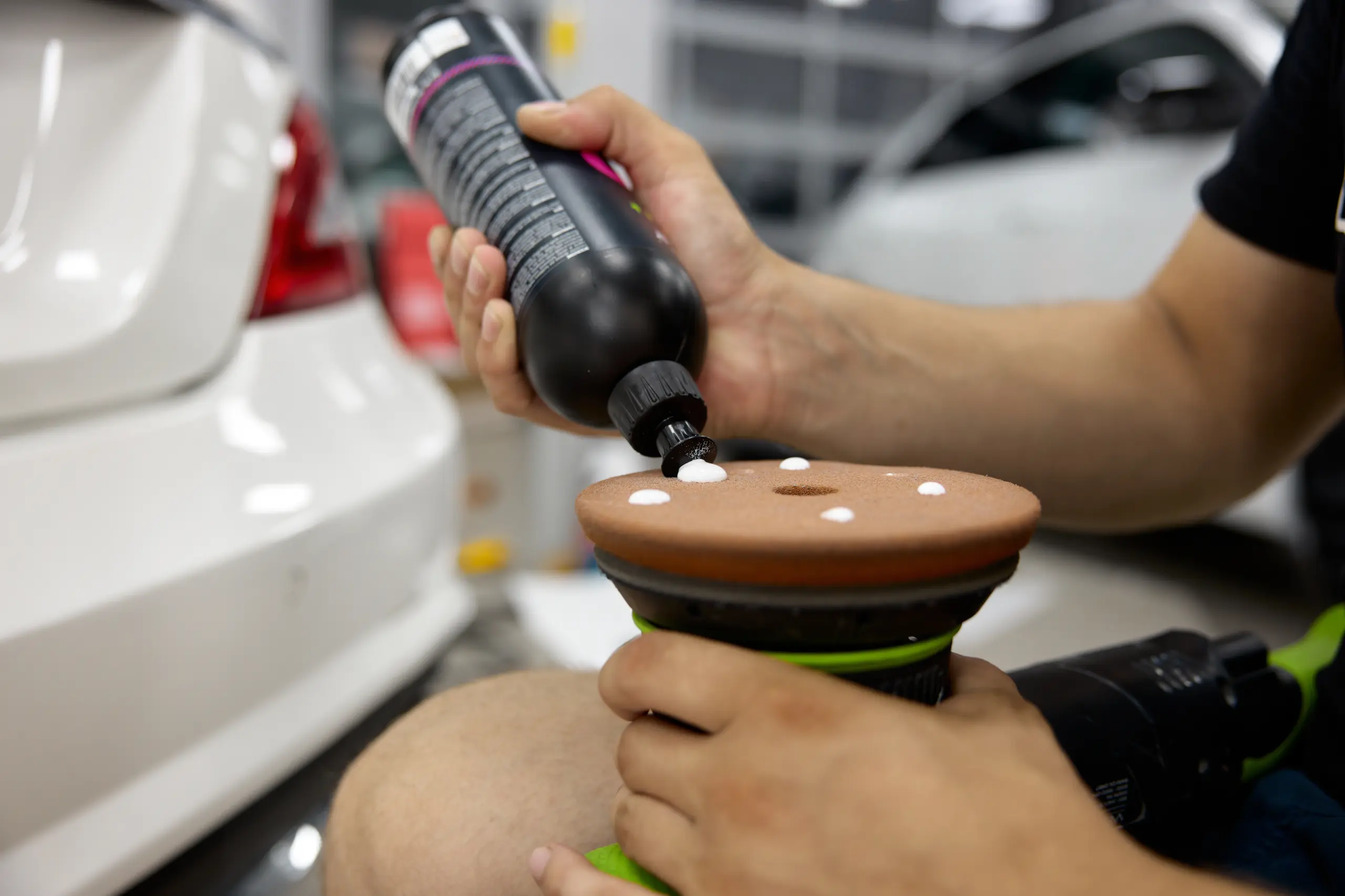 man-car-service-worker-applying-wax-cream-on-disk