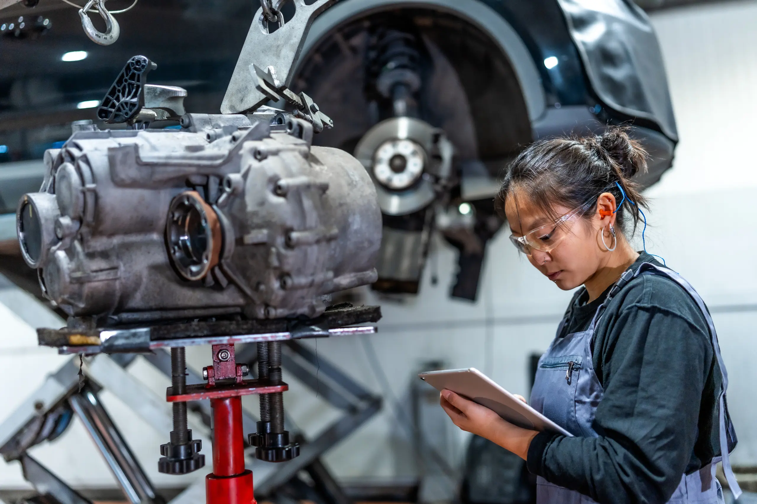 female-mechanic-using-digital-tablet-while-inspecting-gearbox